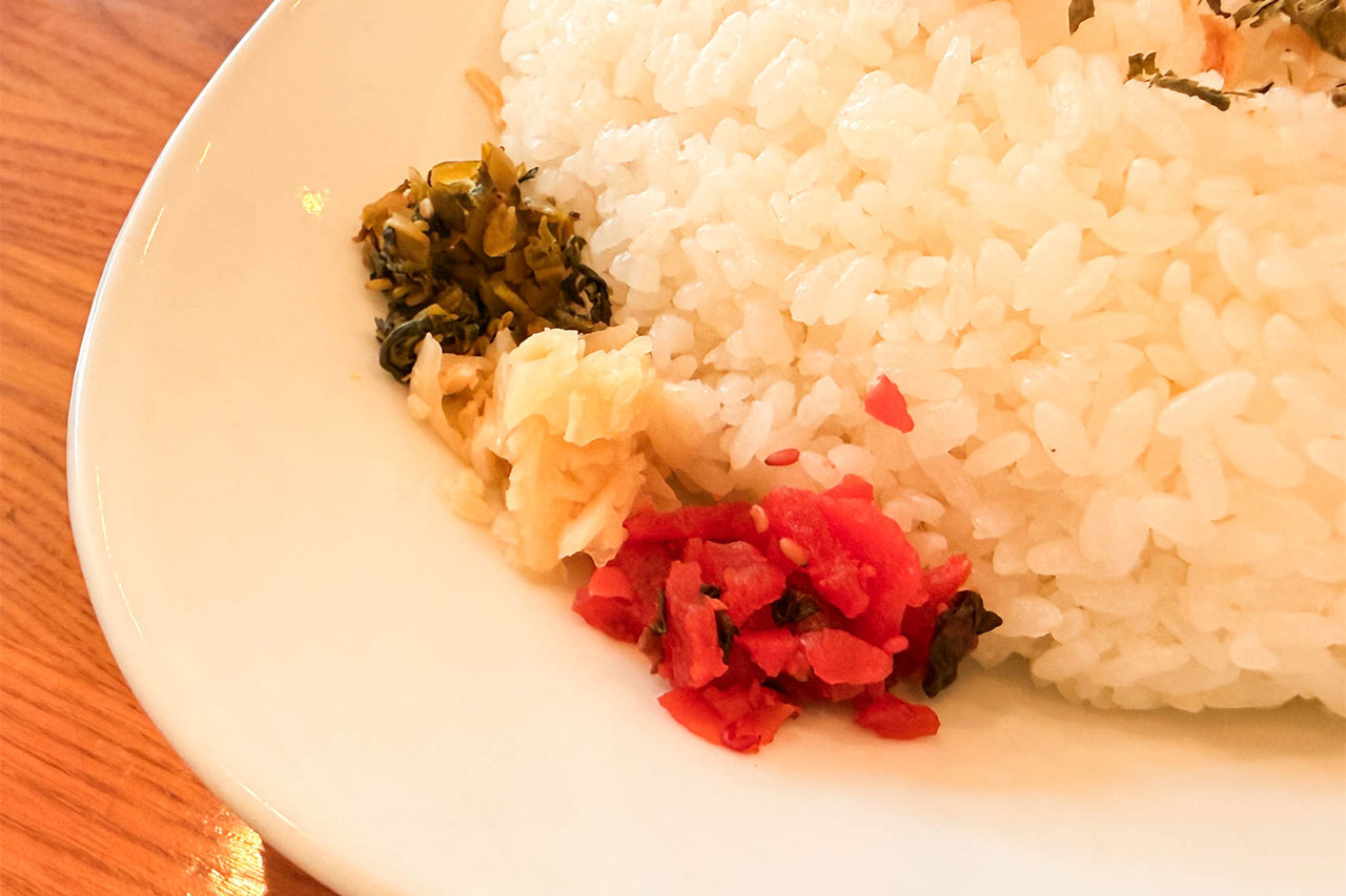 エンドルフィンのポークカレーに添えられた高菜漬けとガリと福神漬け